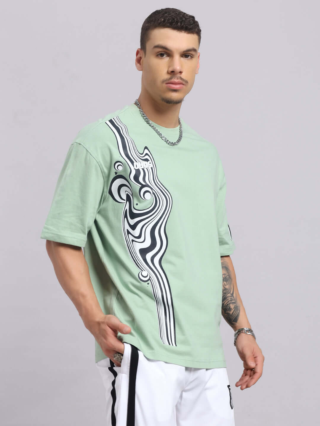 Model wearing Chimera over-sized T-shirt in Nyanza Green with abstract design, made from premium cotton blend, ideal for casual wear.