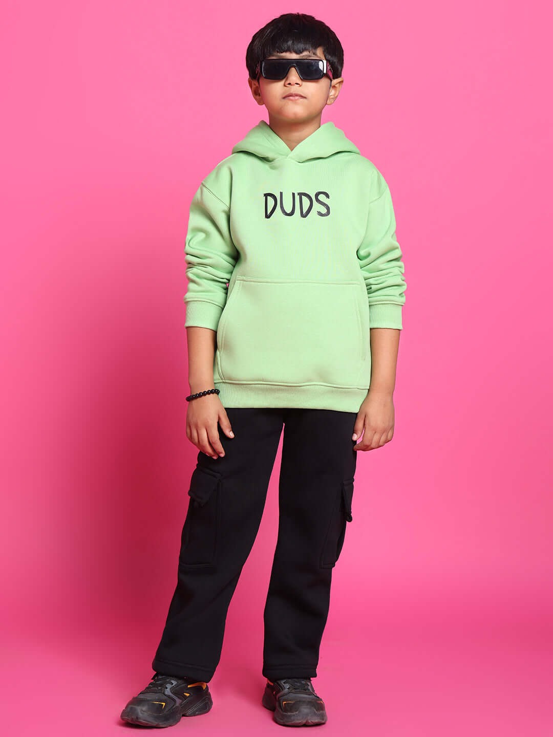 Child wearing ROOAR neon green co-ord set with "DUDS" hoodie on pink background, stylish outfit for boys and girls.
