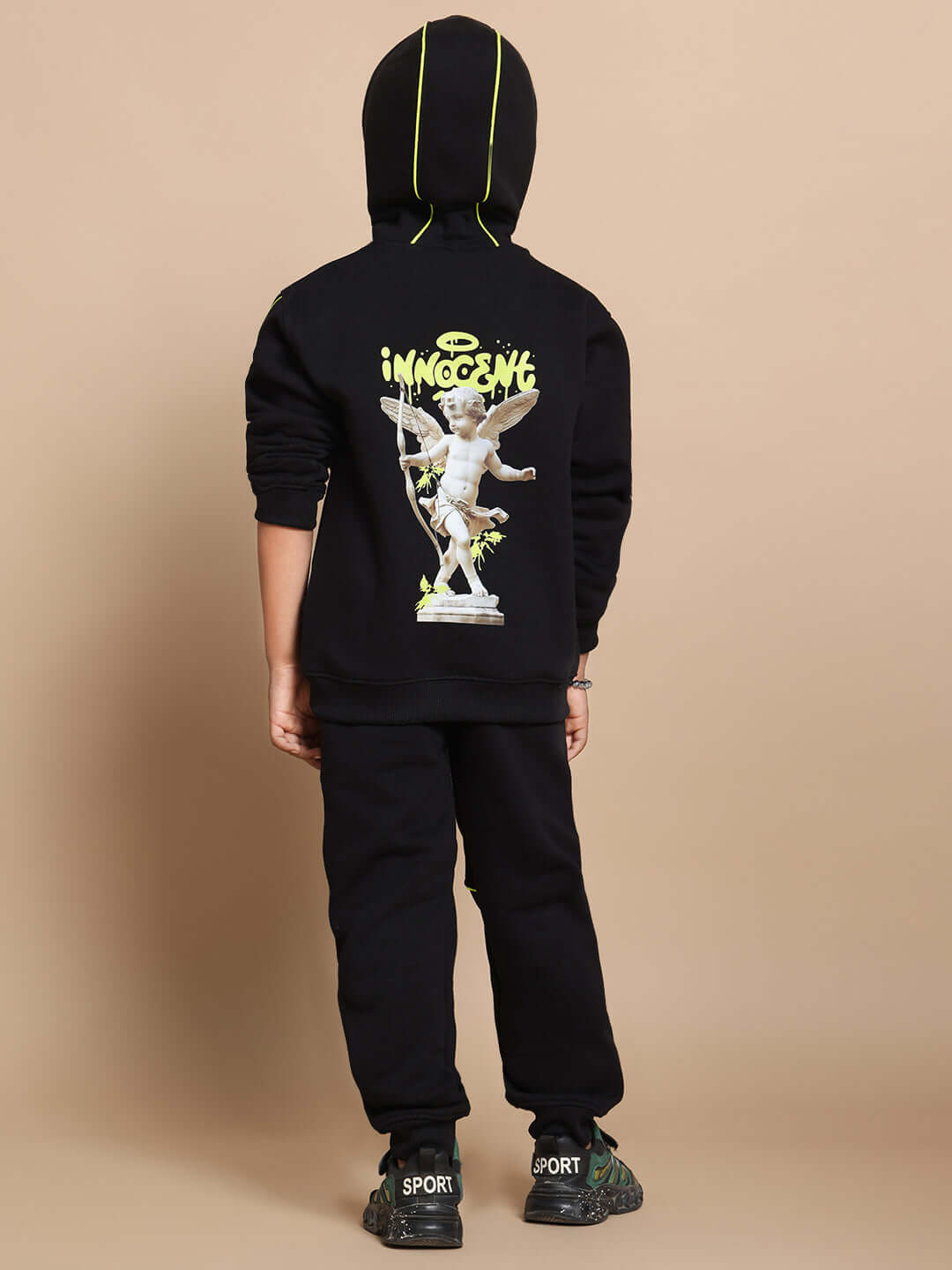 Child wearing black Innocent Fleece Co-ord Set with angel print, showcasing hoodie and joggers. Unisex kidswear for comfort and style.