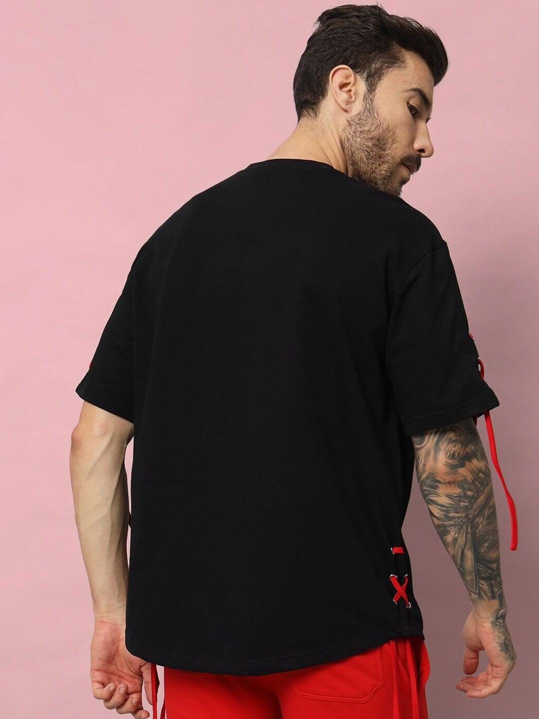 Man wearing a black Bowline oversized t-shirt, made from premium cotton French terry, showcasing back and side details against a pink background.