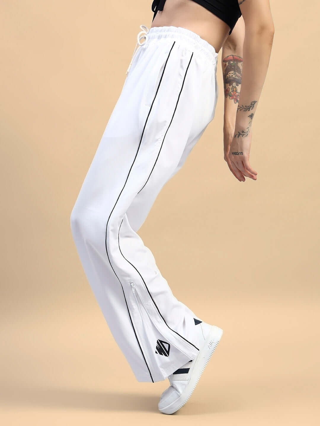 Woman wearing white relaxed-fit joggers with black stripes, showing side view and custom fit design.