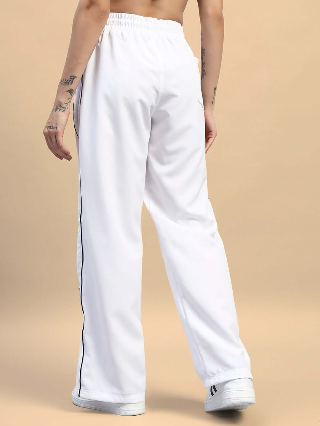 Back view of women's white relaxed-fit joggers with side stripe, showcasing comfortable and stylish design for casual wear.