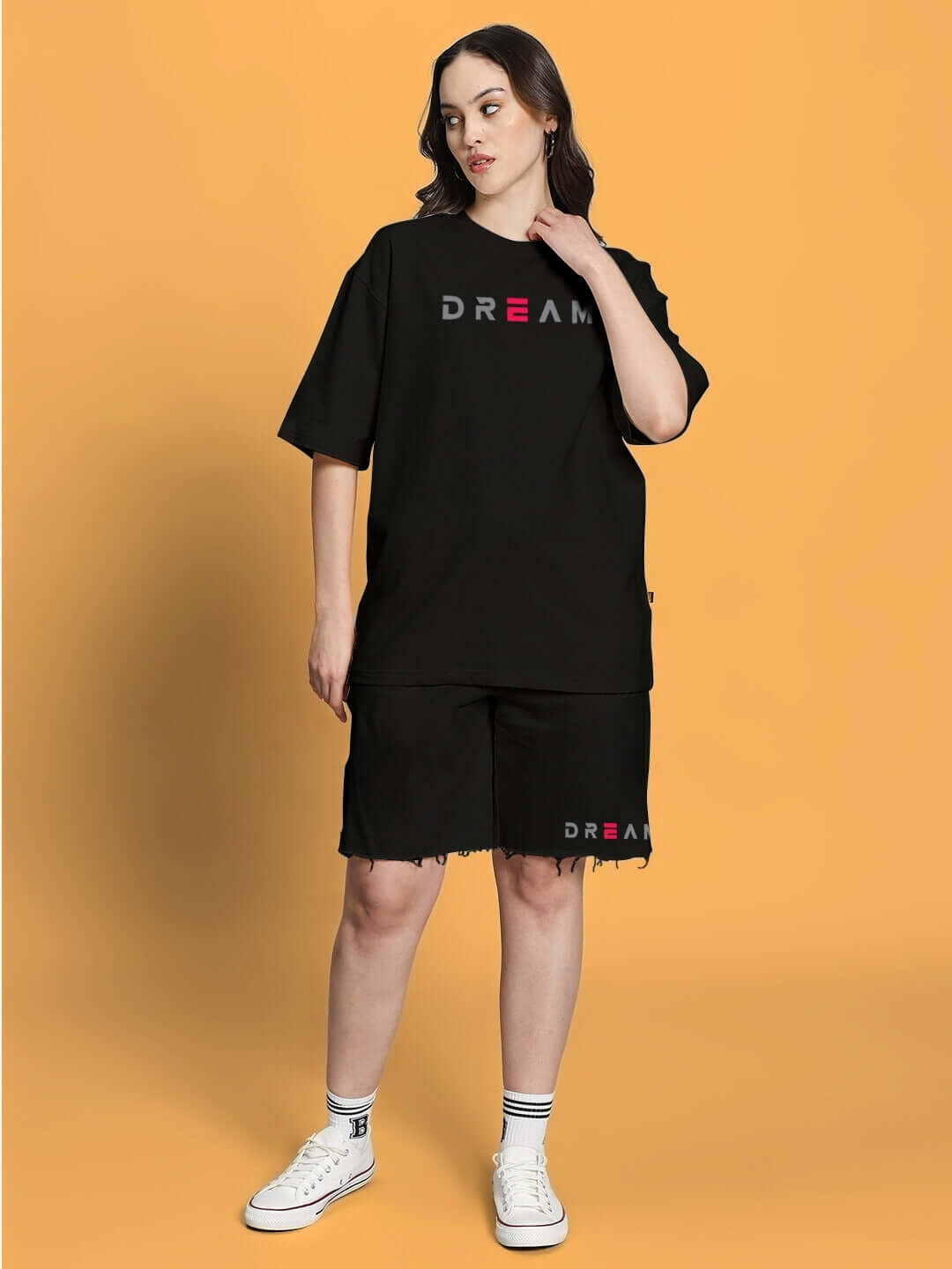 Woman wearing black co-ord set with 'Dream' print, combining premium cotton French Terry Lycra and elastane for comfort and style.