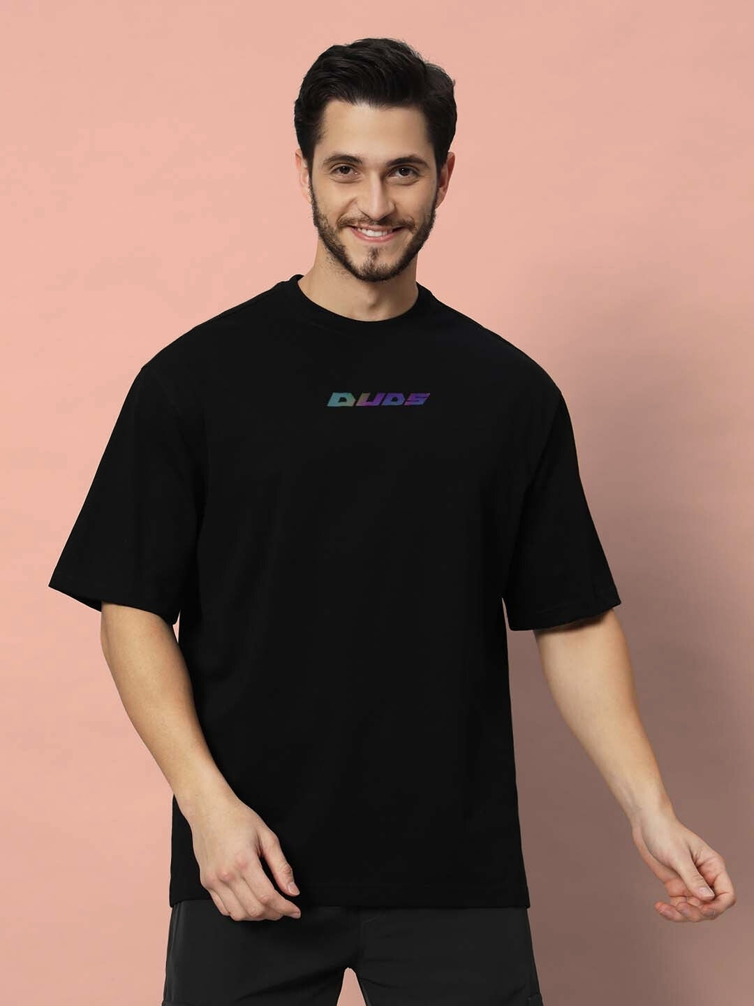 Model wearing black t-shirt promoting DUDS brand. GOHAN OVER-SIZED T-SHIRT OFF WHITE not shown. Custom fit option available.