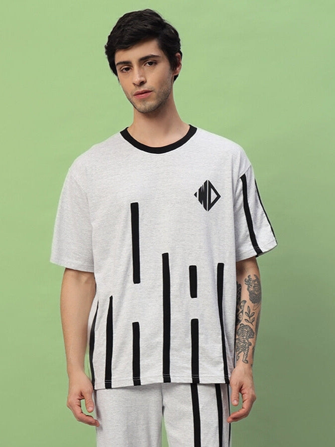 Model wearing Bastille oversized melange grey t-shirt made from premium cotton French terry, showcasing black geometric accents.