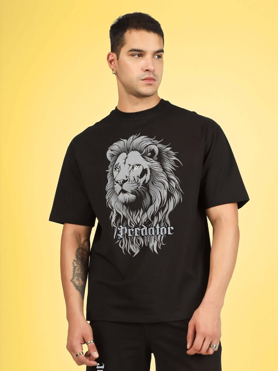 Man wearing black Predator Legend T-shirt with lion graphic, made from 100% cotton, showcasing premium fabric quality.