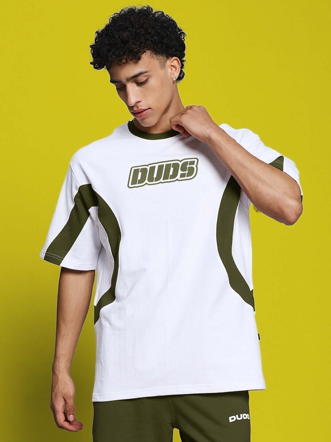 Model wearing EZEL oversized white-grey T-shirt made from premium heavy gauge fabric, showcasing casual style against a vibrant backdrop.