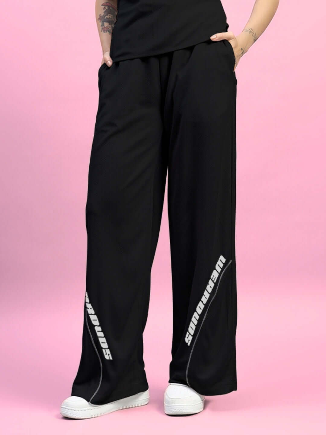 Black women's cubby relaxed fit baggy joggers with custom fit option on a pink background, showcasing comfortable design.