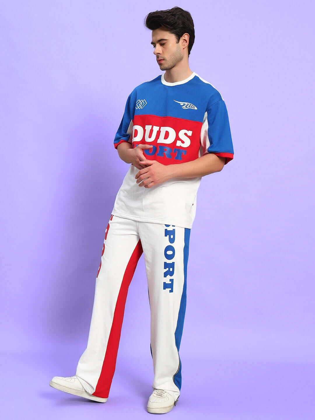 Model wearing URBAN DRIFT relaxed fit co-ord set in multi-color, crafted from premium cotton French Terry Lycra, standing against purple background.