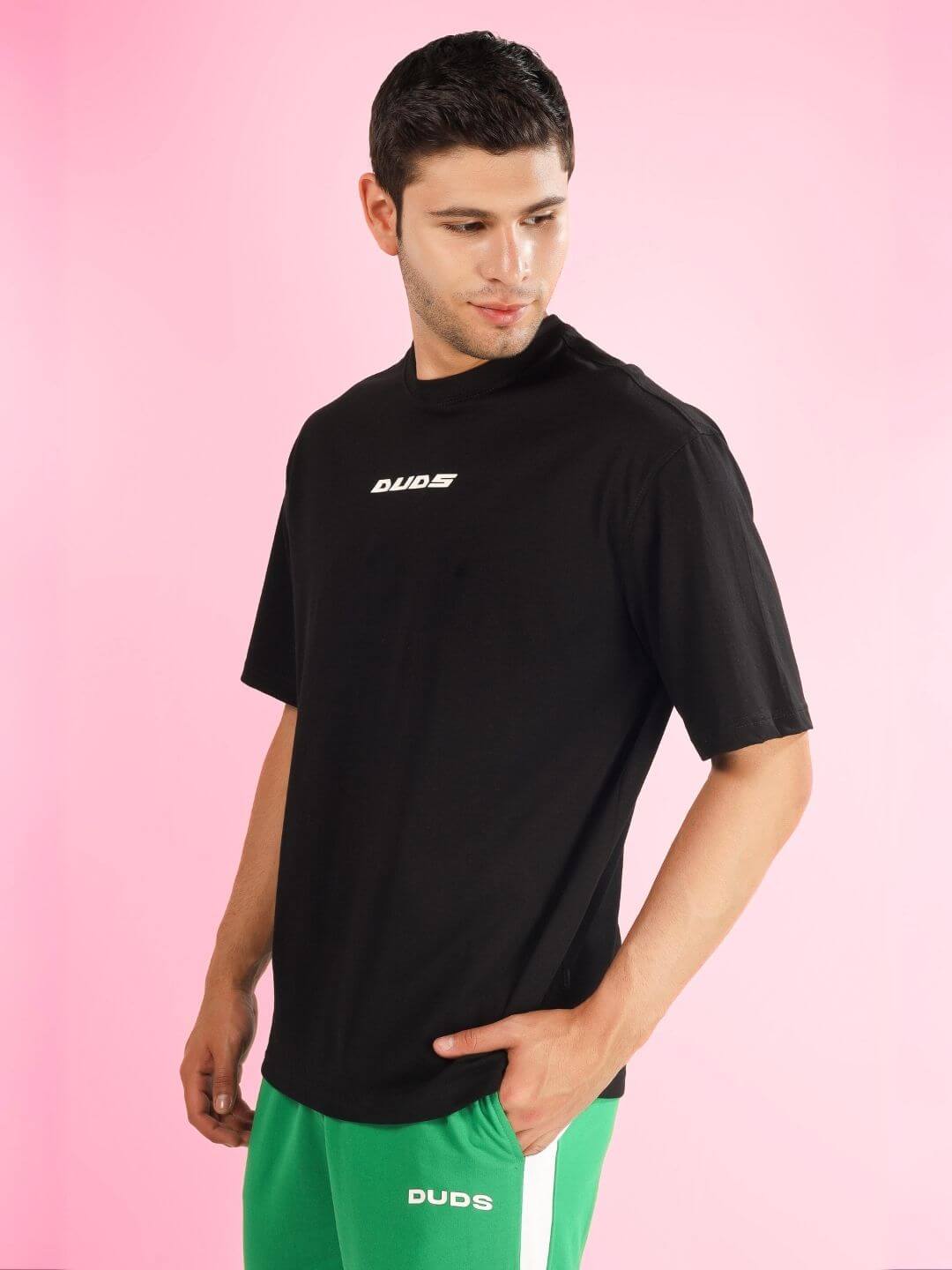Model wearing ENJOY THE WIND OVER-SIZED T-SHIRT BLACK by DUDS, shown from the front in a casual pose.