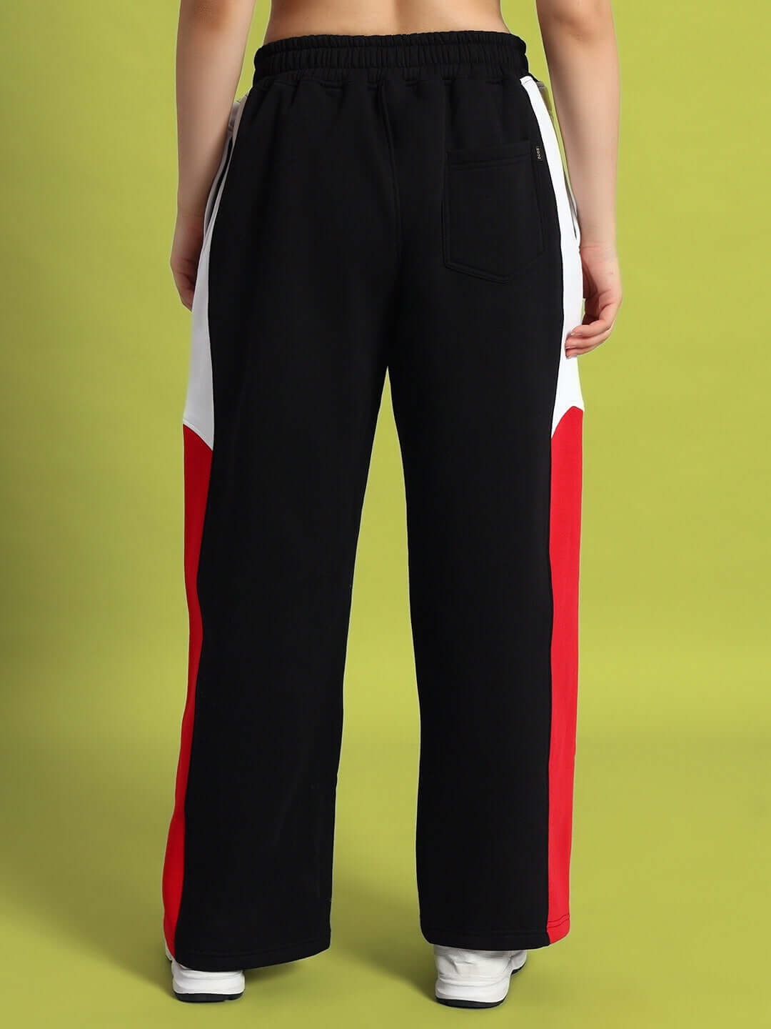 Back view of women's black colorblock cargo pants with red and white panels, showcasing streetwear style and utility pockets.
