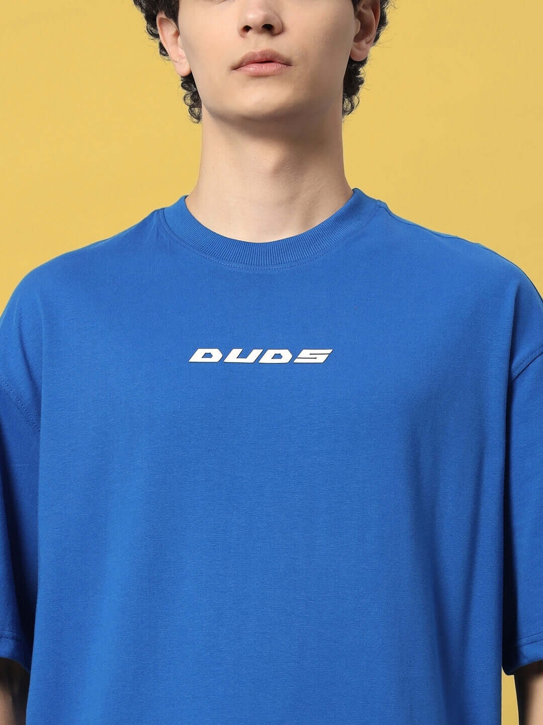 Alt Tag: VICTORY OVER-SIZED T-SHIRT ROYAL BLUE by DUDS on a model, showcasing casual fashion in vibrant royal blue color.
