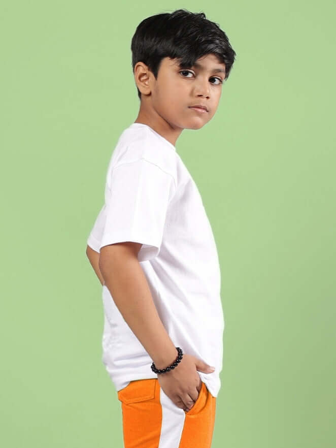 Young boy wearing a white crossover t-shirt, perfect for boys and girls. Stylish and comfortable attire suitable for casual wear.