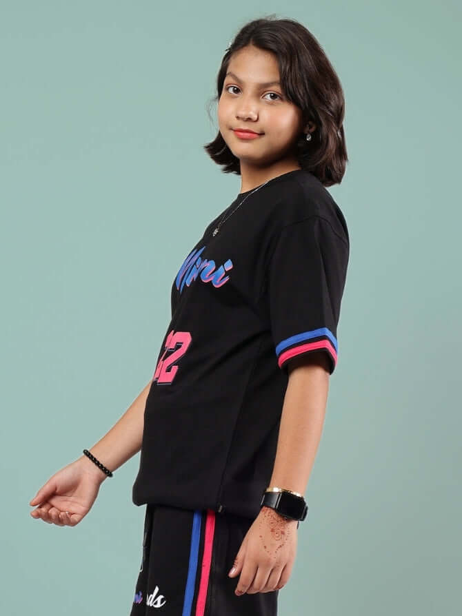 Child wearing Miami oversized black t-shirt by DUDS, customizable fit, made by experienced tailors, side view, casual fashion.