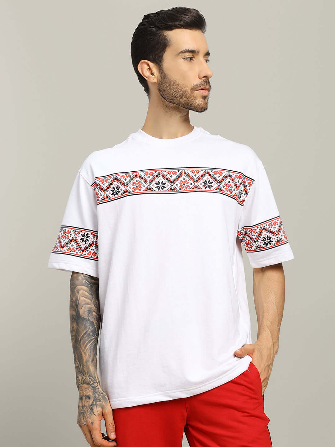 White Vyshyvanka print T-shirt featuring red traditional patterns, made of premium cotton blend, worn by a male model.
