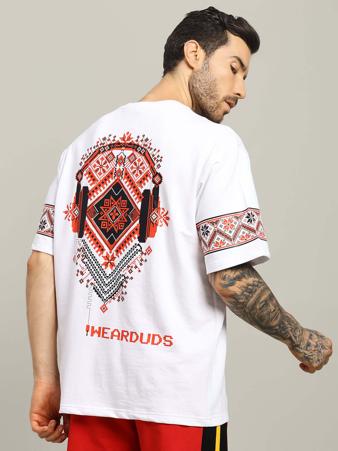Model wearing white Vyshyvanka print T-shirt, featuring headphone ornament design, made from cotton-elastane blend fabric.