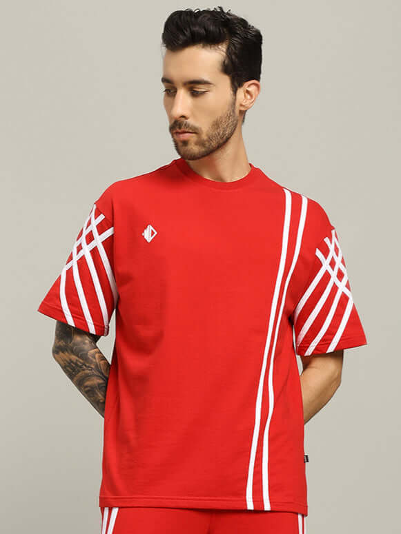 Model wearing red oversized T-shirt with white stripes, made of premium cotton blend from India, designed by Color By Colours.