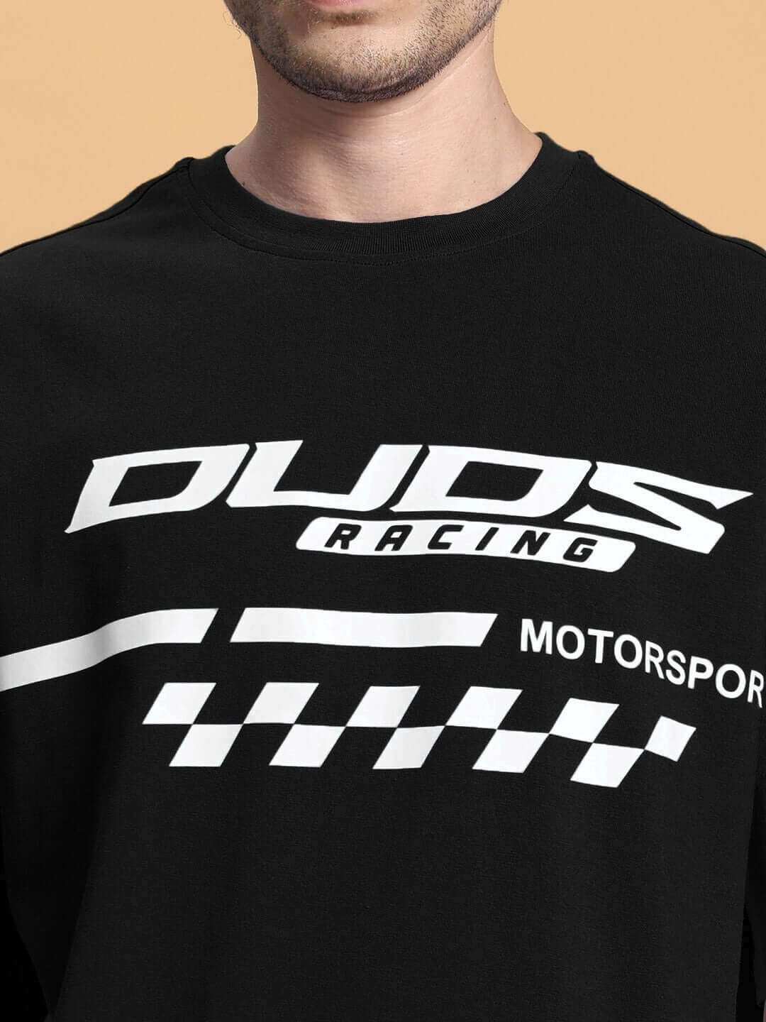Man wearing black t-shirt with DUDS Racing Motorsport logo in white.