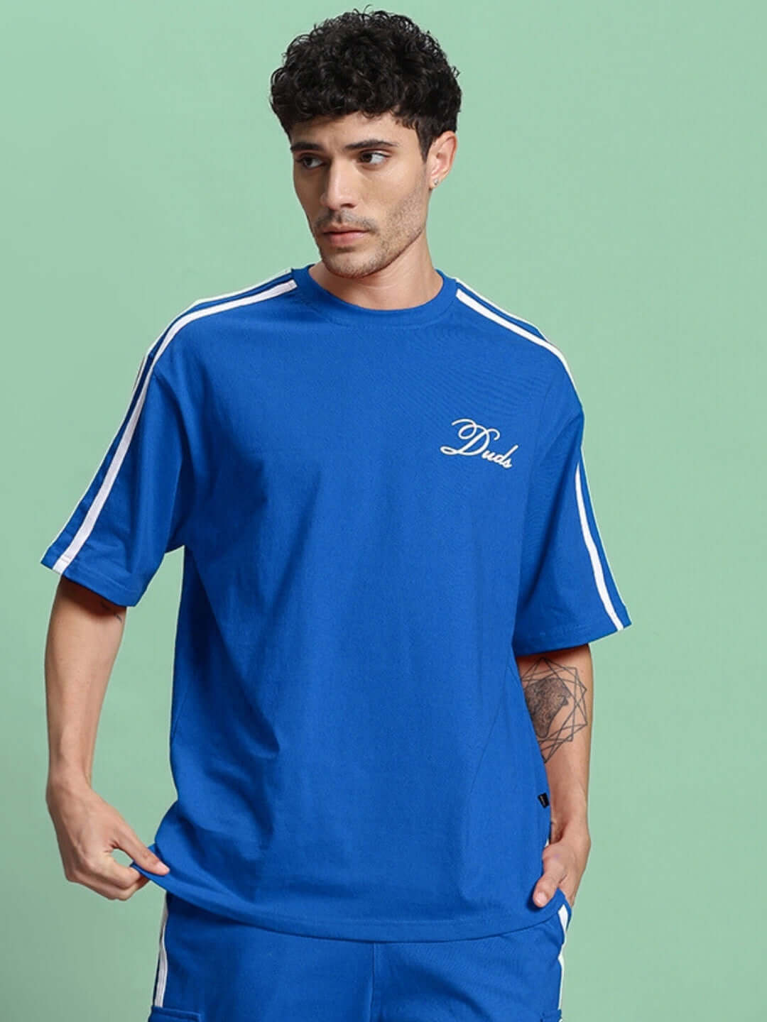 Model wearing blue oversized T-shirt with stripes, made of premium cotton French terry, ideal for casual wear.