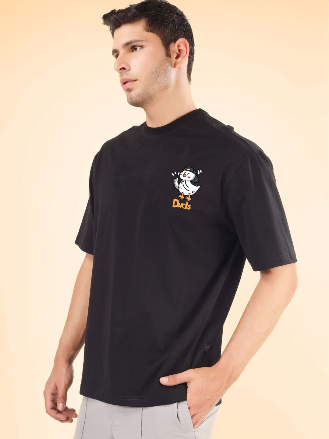 Man wearing GO MOTION OVER-SIZED T-SHIRT BLACK with a graphic design on the chest.