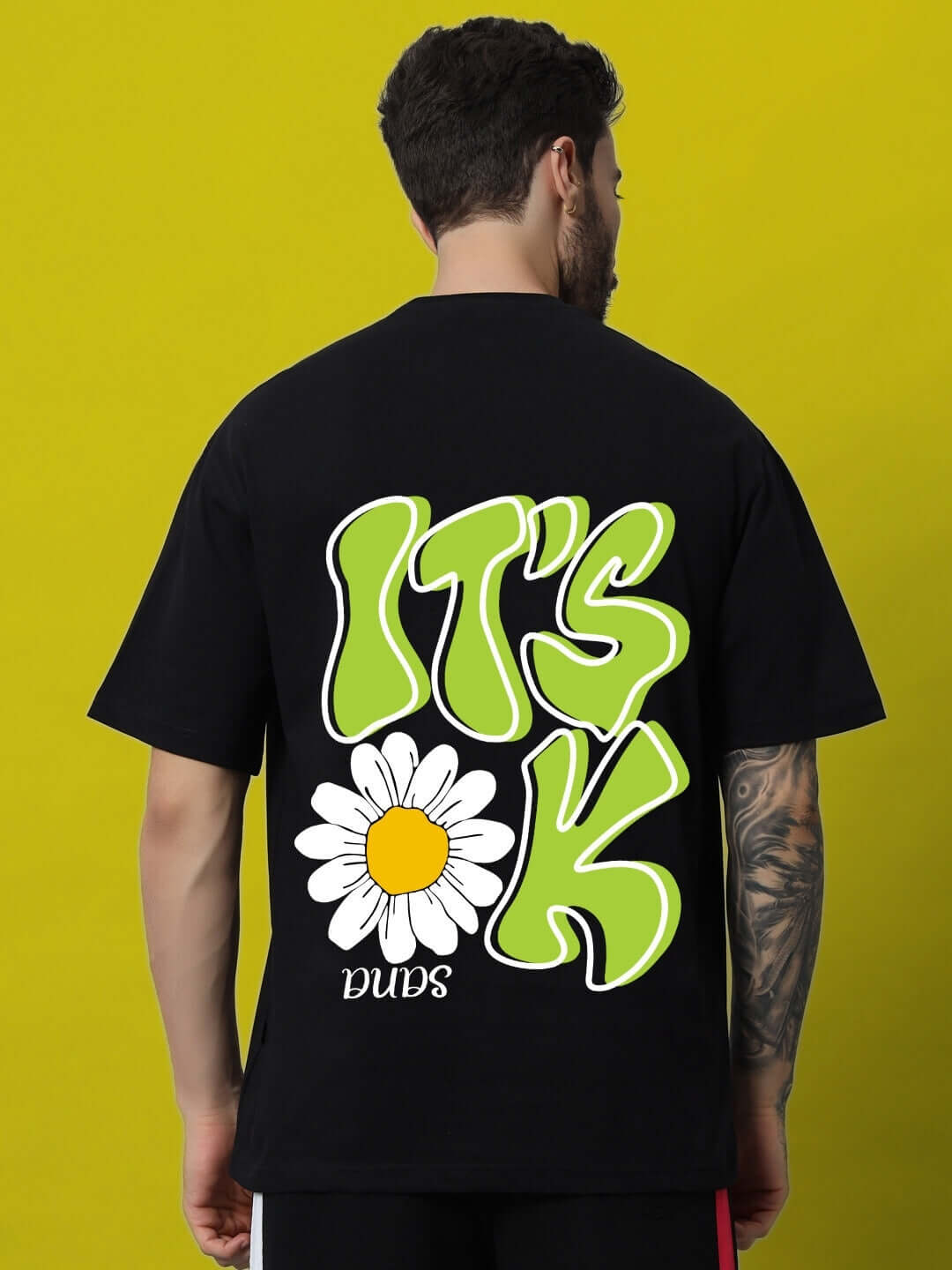 Black oversized T-shirt featuring bold 'IT'S OK' print with a daisy design, made from 100% cotton premium heavy gauge fabric.