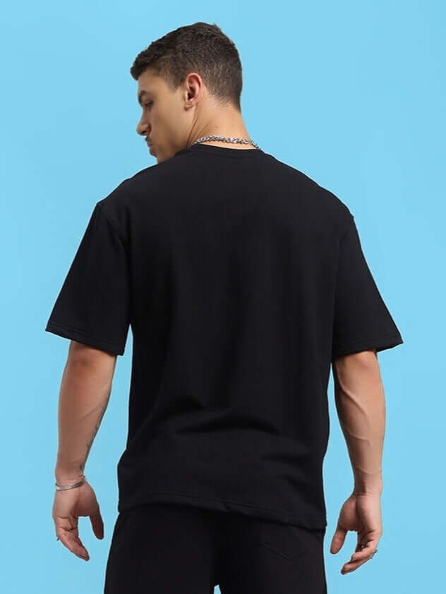 Model wearing Hollister oversized black t-shirt, premium cotton French terry, perfect for casual wear. Made in India. Bio-washed fabric.