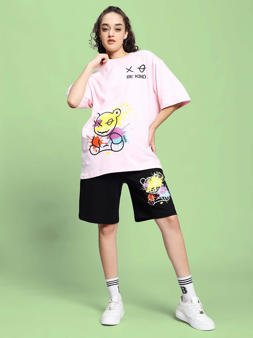 Woman wearing Women's Be Kind Summer Co-ord Set in Pink and Black, featuring a colorful graphic design. Made with premium cotton French terry.
