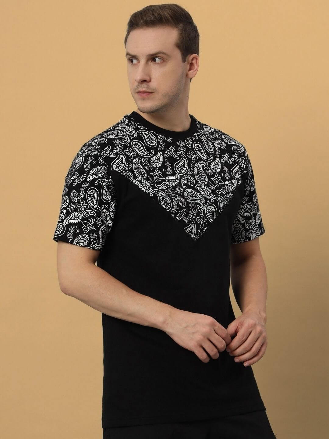 Man wearing Balladeer over-sized black T-shirt with paisley print, made from premium cotton French terry, bio-washed for softness.