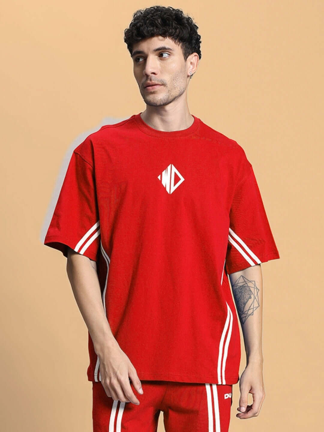 Model wearing red oversized T-shirt made of premium cotton and elastane, featuring white stripes and logo design, ideal for casual wear.