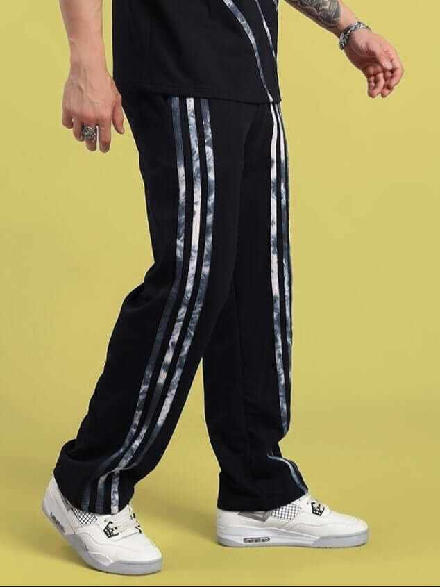 Person wearing FLICKER JOGGER in black with striped design, showcasing casual style, available for custom fit, made by DUDS tailors.