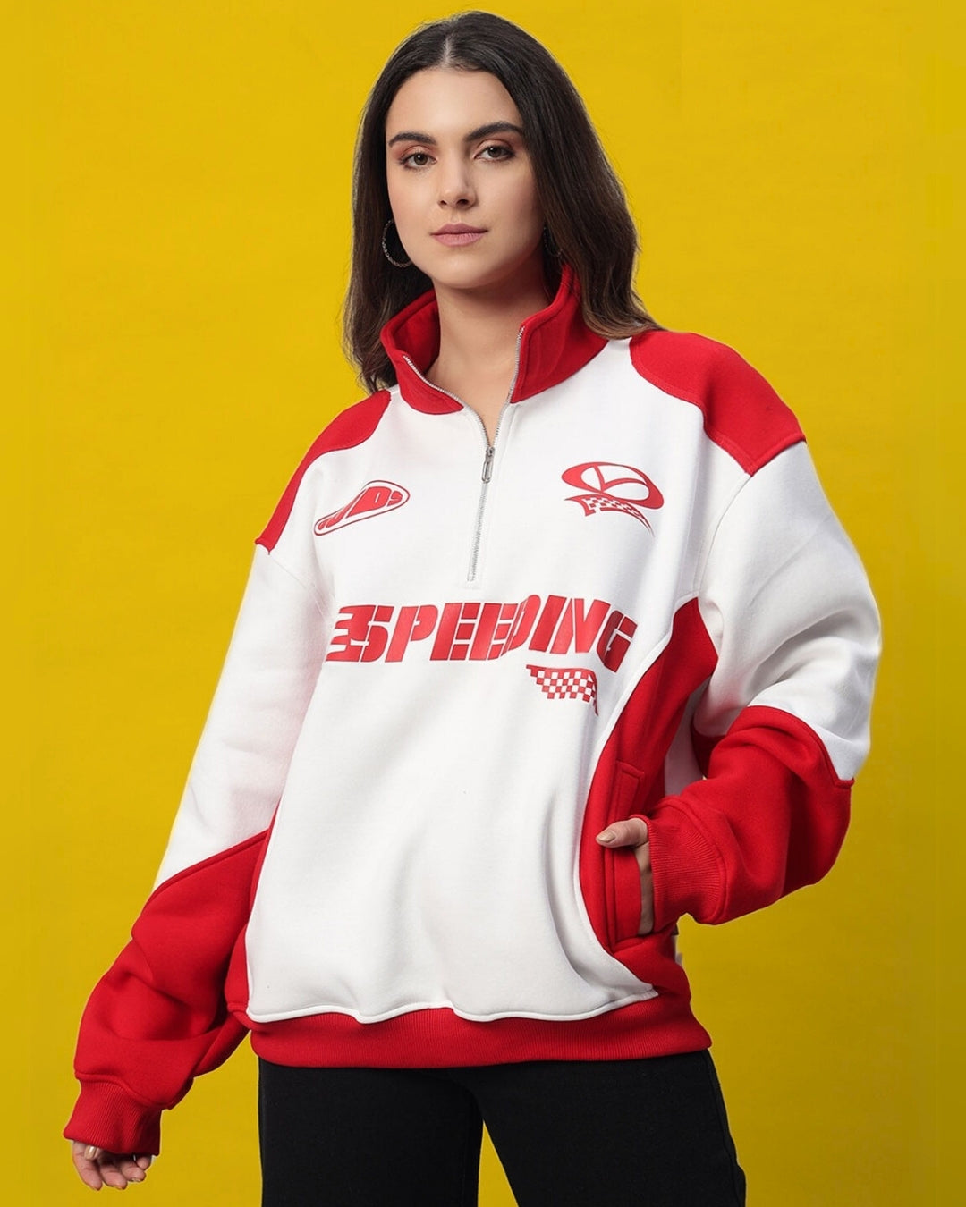 Woman wearing a red and white colorblock jacket with "Speeding" text, standing against a yellow background.