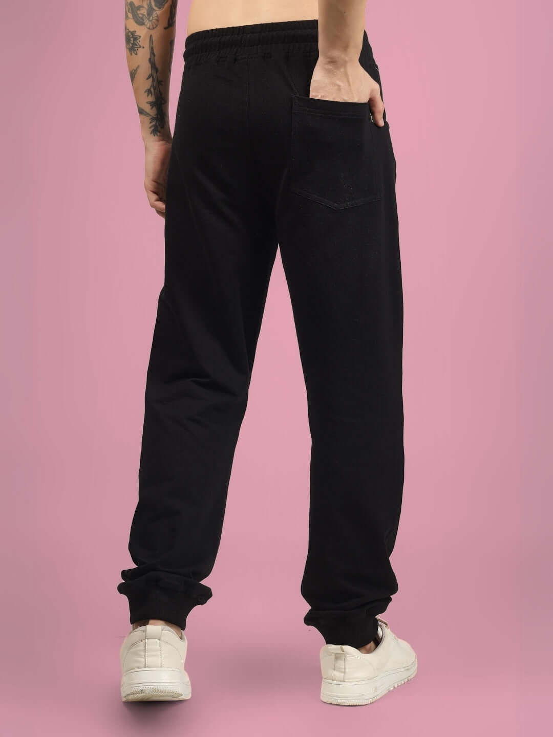 Rear view of a model wearing 2 ZIPPER POCKET COTTON JOGGER BLACK showcasing sleek and comfortable streetwear fashion.