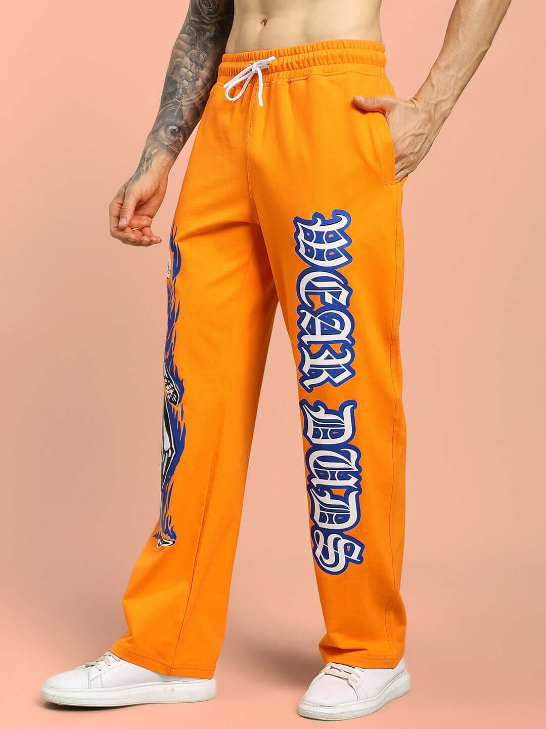 Orange relaxed fit jogger with flaming skeleton print and 'WEAR DUDS' lettering, showcasing unique custom design.