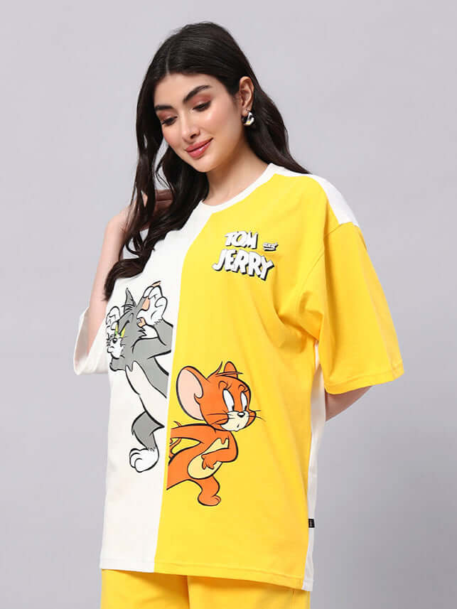 Woman wearing oversized Tom & Jerry t-shirt in off-white yellow, perfect for a trendy summer look with breathable cotton fabric.