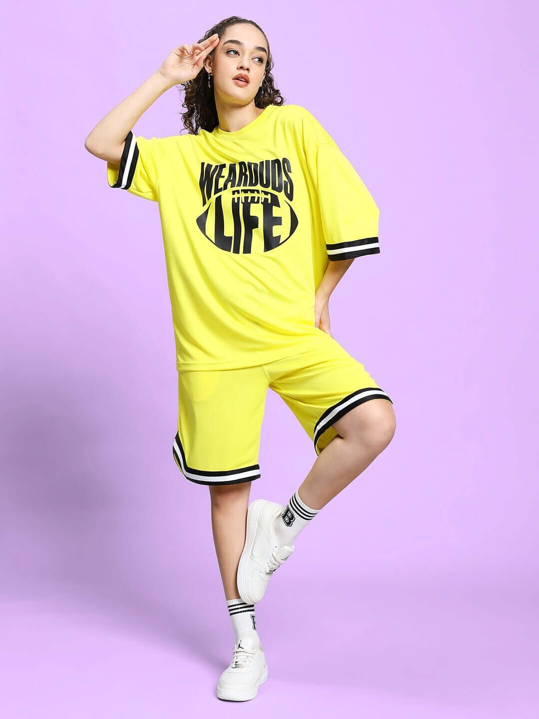 Yellow women's Vigor colorblock co-ord set, sports polyester fabric. Model posing confidently against a purple background.