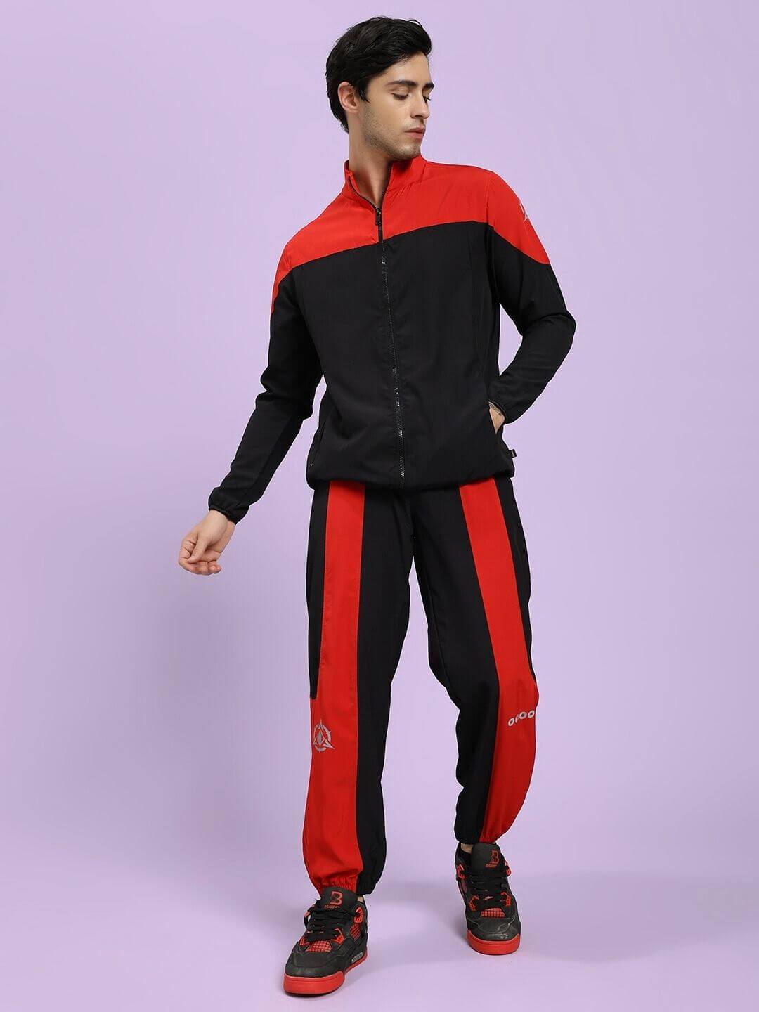 POWER BLOCK CO-ORD SET BLACK RED Person wearing a black and red tracksuit on a light purple background
