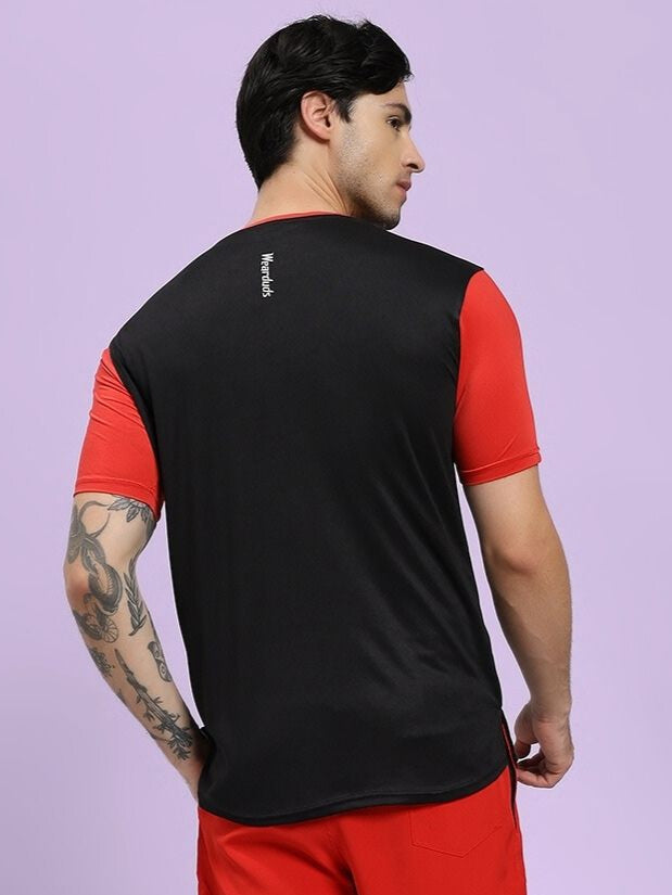 Person wearing a black and red sports outfit on a light purple background