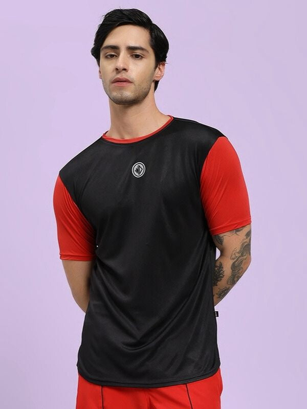 Person wearing a black and red athletic outfit on a light purple background