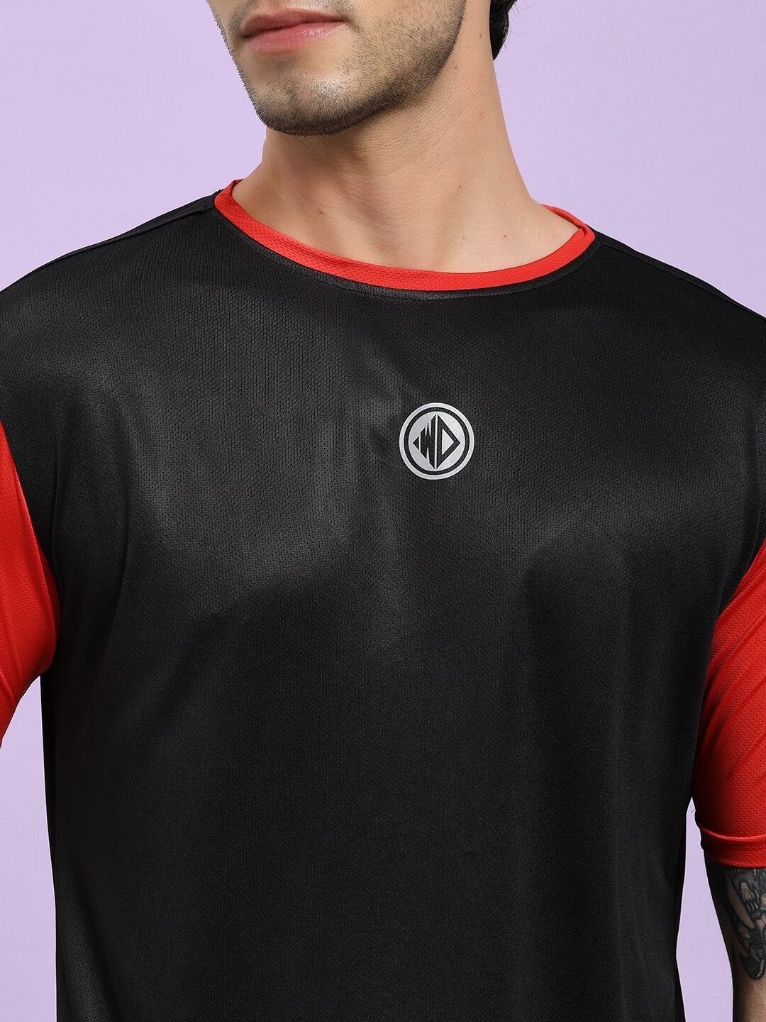 Black and red sports jersey with a logo on a light purple background