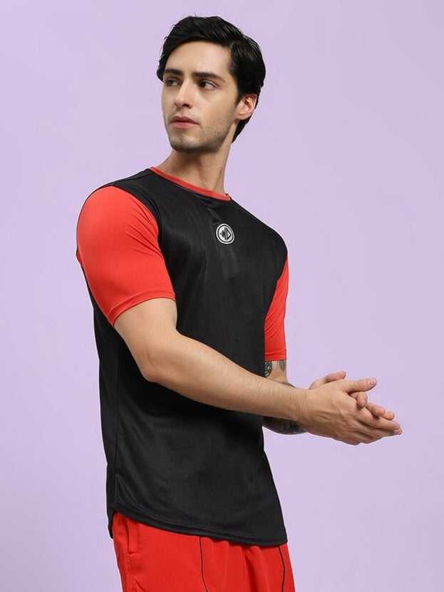 Man wearing a black and red sports outfit with a logo on a light purple background