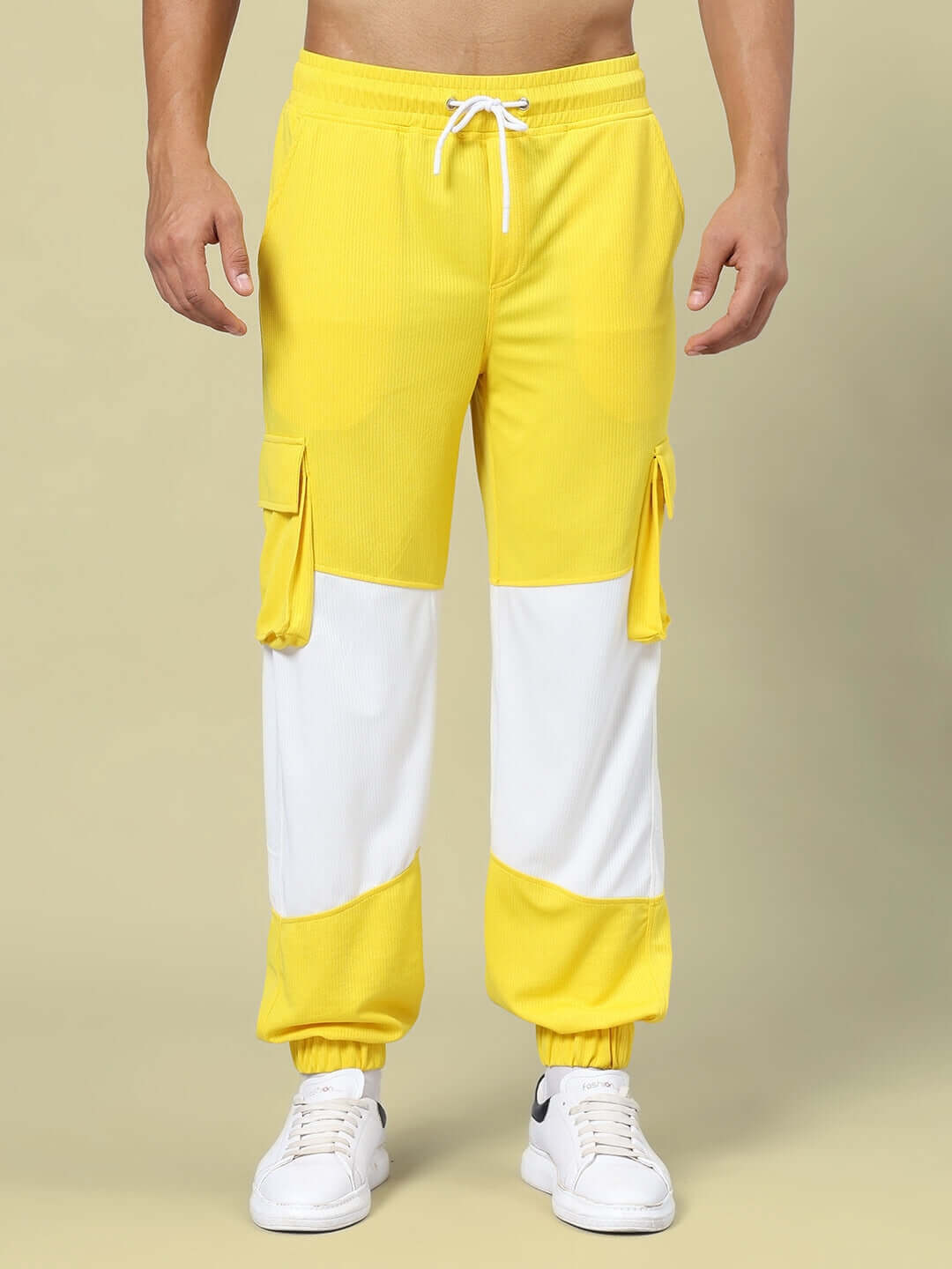 Man wearing Radiant Relaxed Fit Joggers in yellow and white with pocket details and drawstring waist.