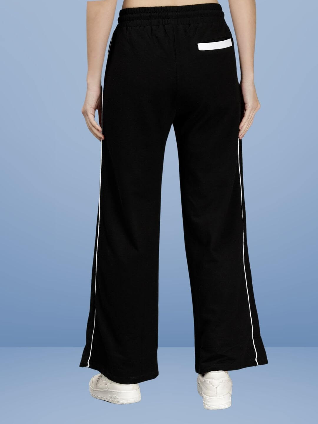 Back view of WOMEN RIO RELAXED FIT JOGGERS BLACK showcasing relaxed silhouette in classic black with white side stripes for effortless style.