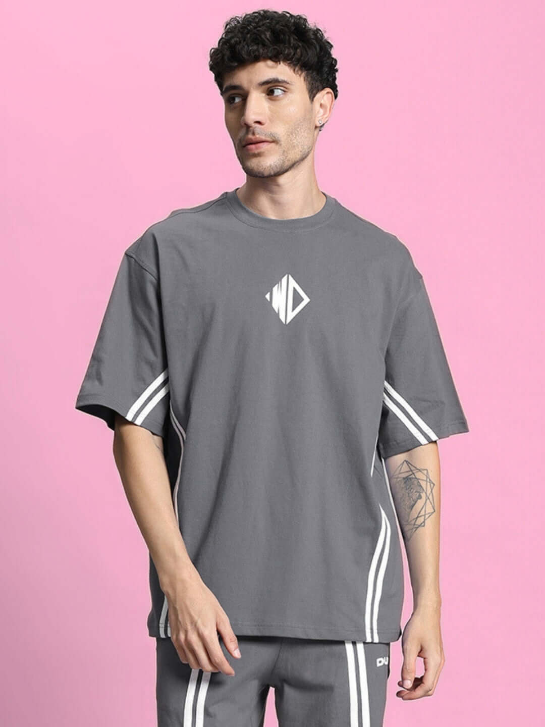Alt Tag: Model wearing grey oversized T-shirt made from premium cotton blend, featuring a unique design, perfect for casual wear.