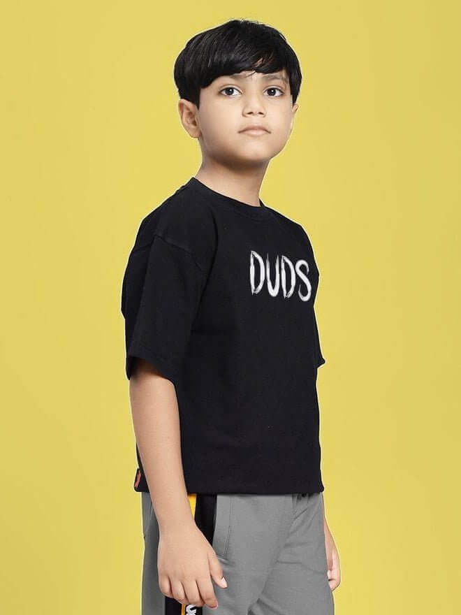 Boy wearing MINING THE MOONLIGHT PRINT T-SHIRT FOR BOYS AND GIRLS BLACK against a yellow background