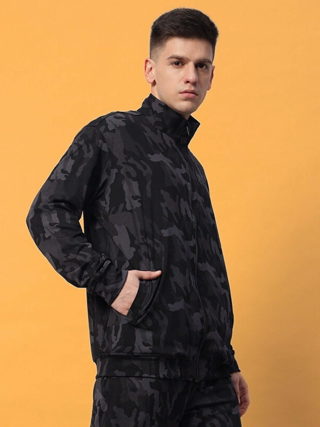 Man wearing a DEFENCE Camo Navy jacket by DUDS against orange background, showcasing unique design and custom fit option.