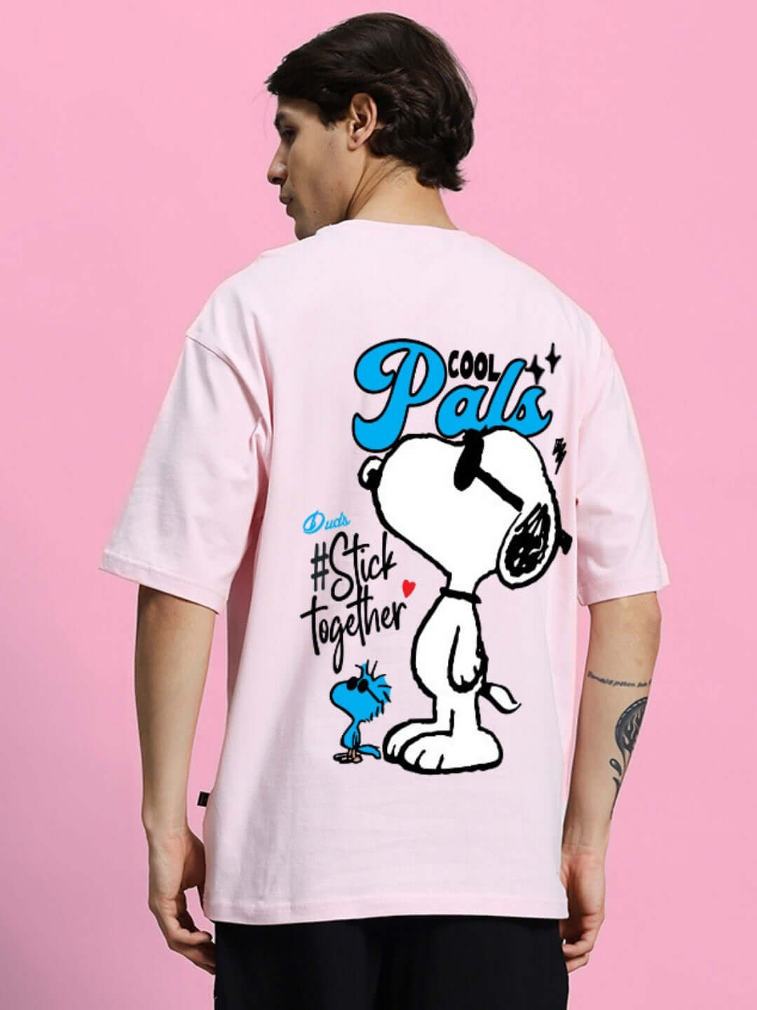 Man wearing Cool Pals printed oversized pink T-shirt with cartoon design, premium cotton fabric, 200 GSM bio-washed, made in India.