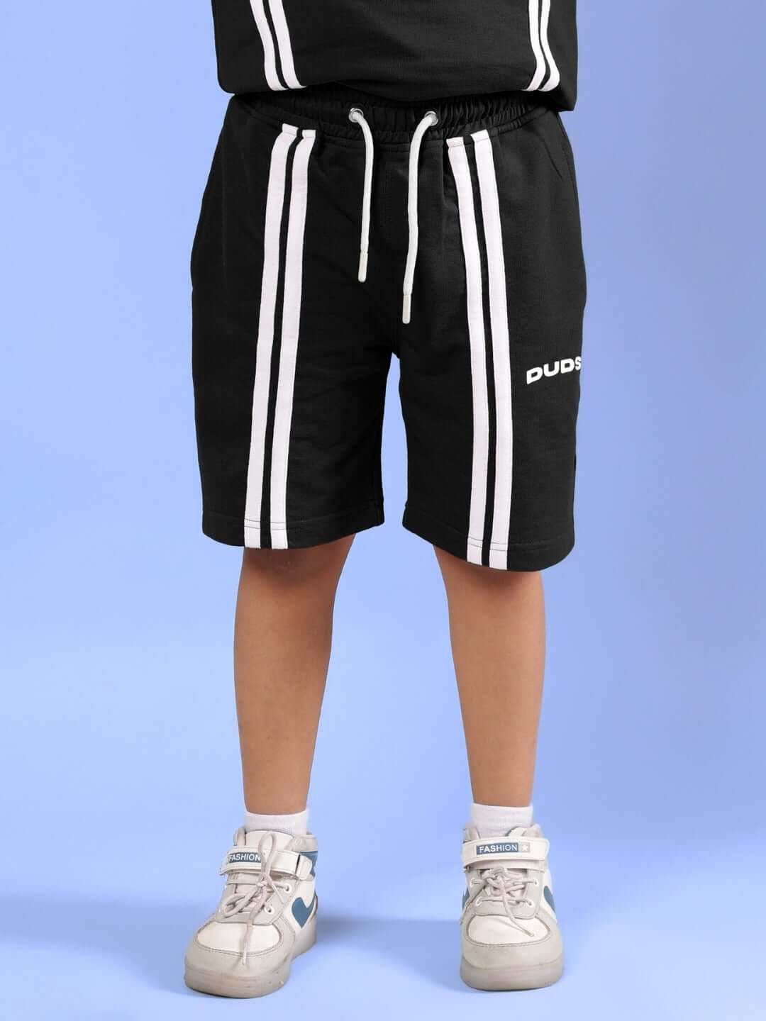 Child wearing a black Outlook Half Co-ord set with white stripes, featuring adjustable drawstring shorts by DUDS, suitable for boys and girls.