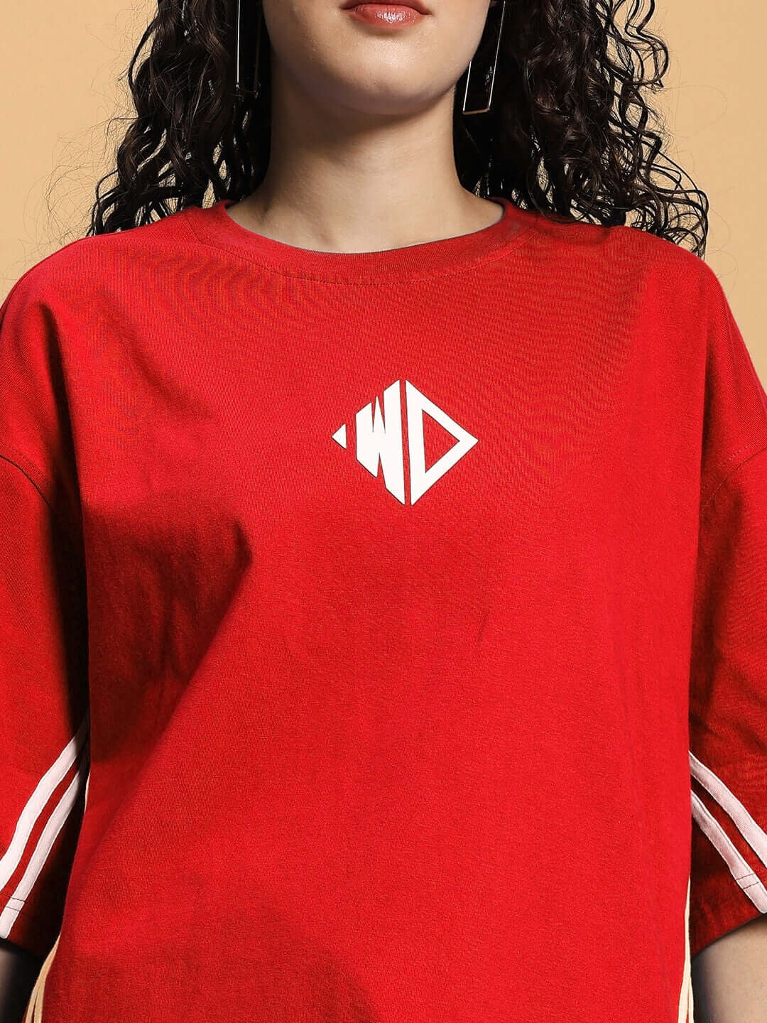 Woman wearing red oversized t-shirt made of premium cotton French terry with logo, promoting women's fashion and comfort.