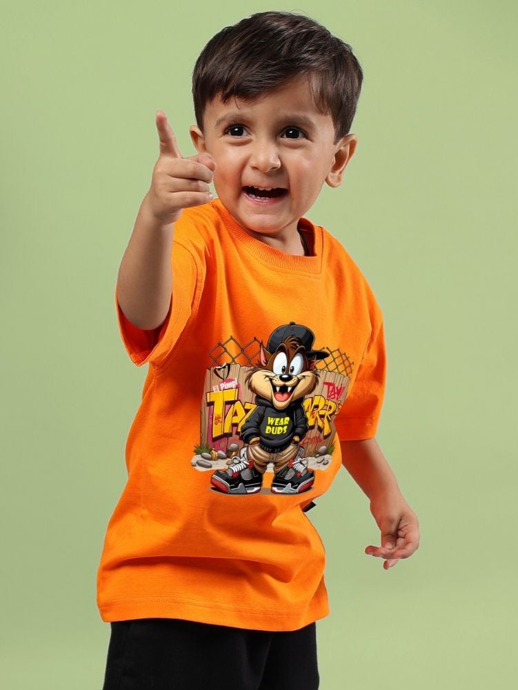 Young boy wearing vibrant orange Crazy Rapper t-shirt with street art design, pointing forward, showcasing hip-hop culture style.