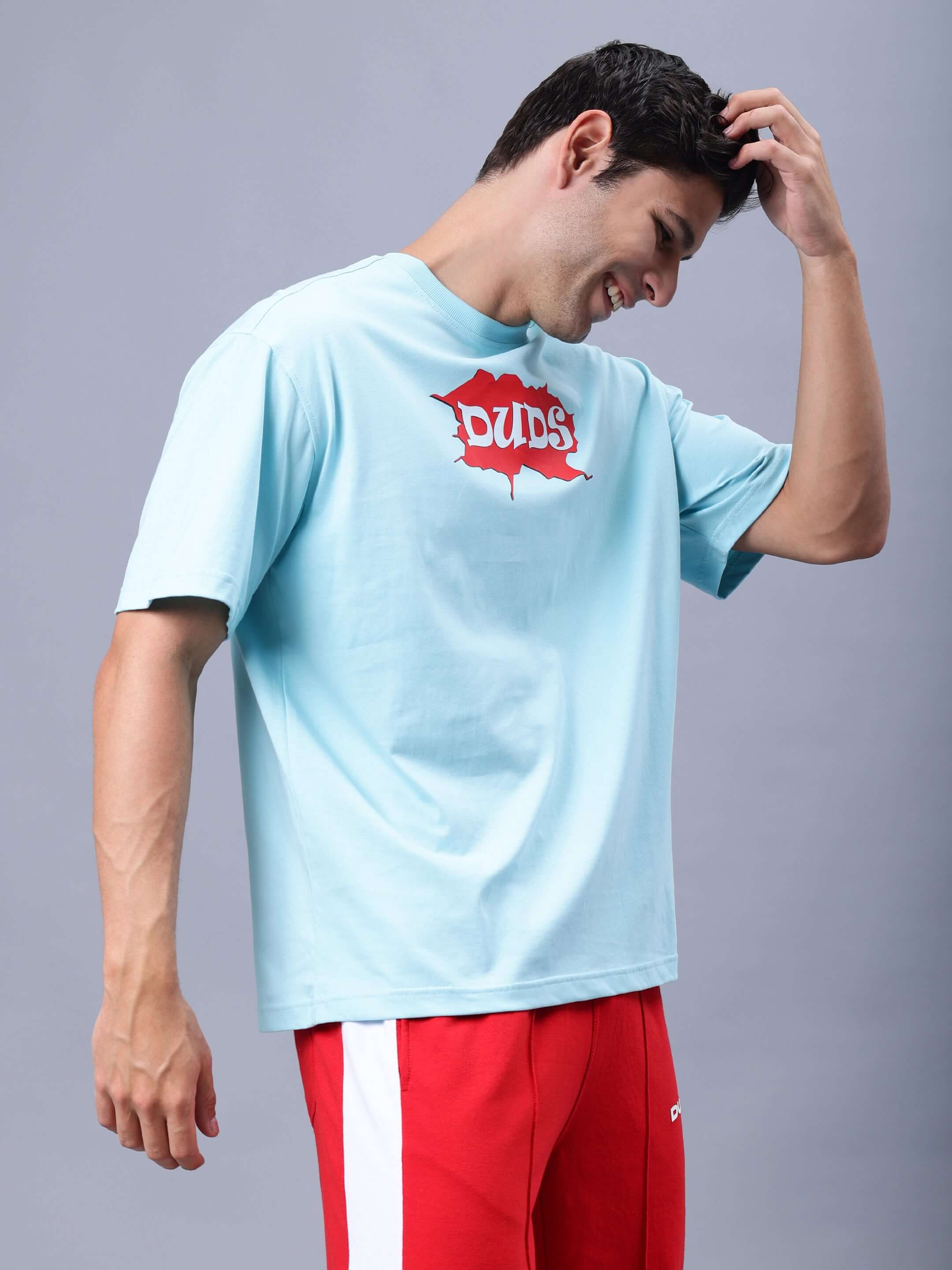 RADIO OVER-SIZED T-SHIRT SKY BLUE worn by model, featuring red DUDS logo; customizable fit option available.
